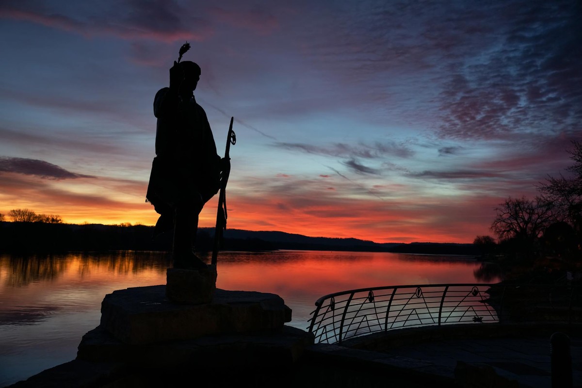 Scenic silhouette of a statue against a vibrant sunset in Wabasha, Minnesota.