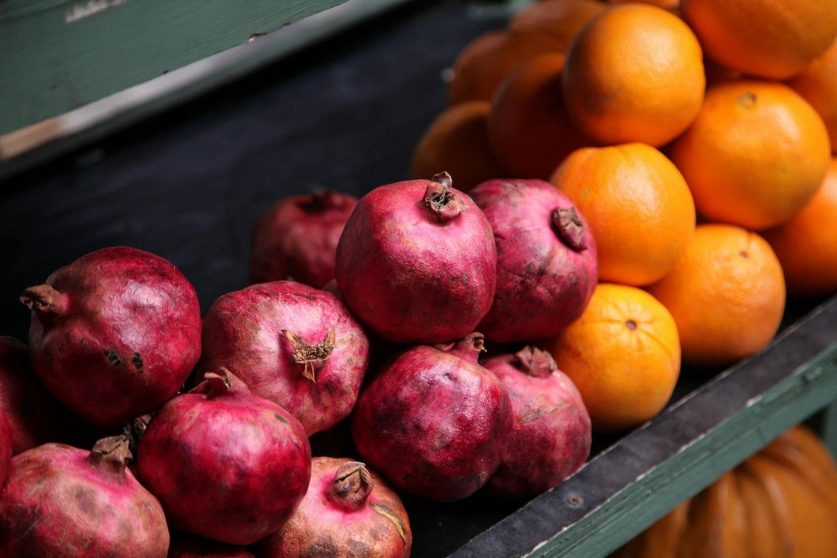 Vibrant display of ripe pomegranates and oranges at a market stall in Tbilisi, Georgia.