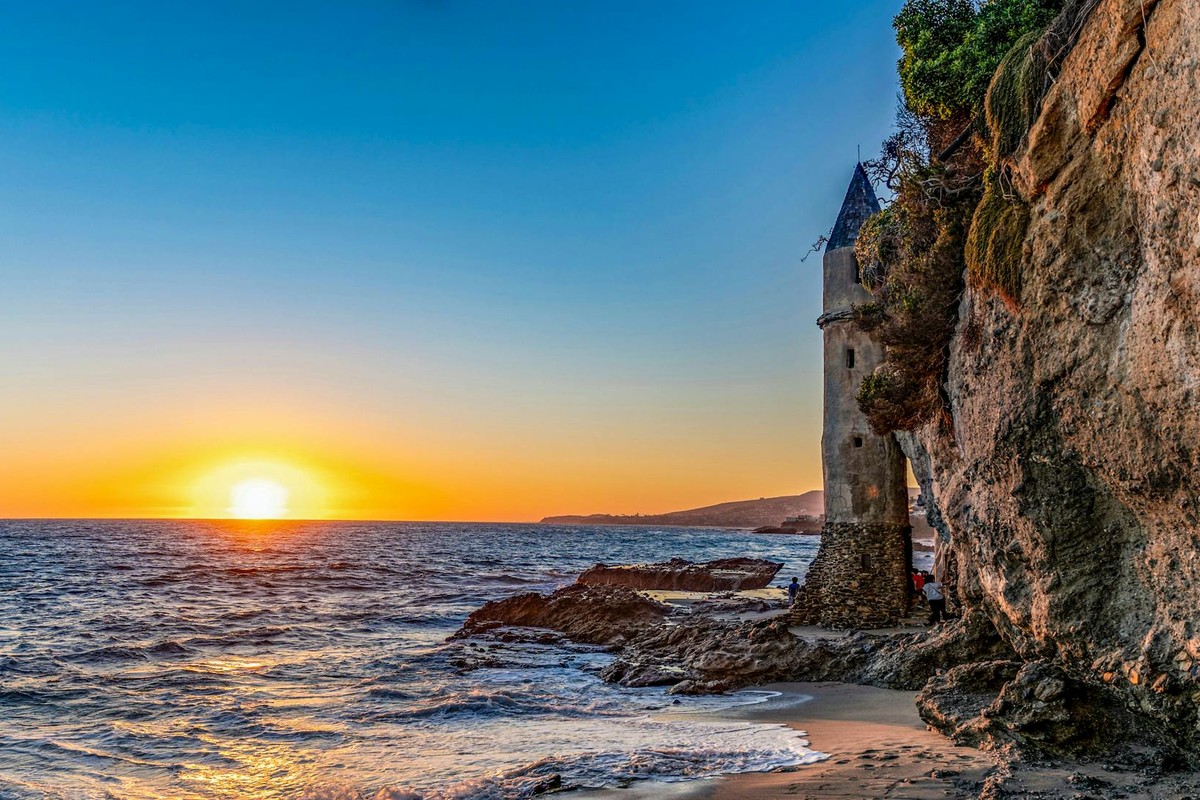Witness the enchanting Pirate Tower at Laguna Beach during a vibrant sunset.