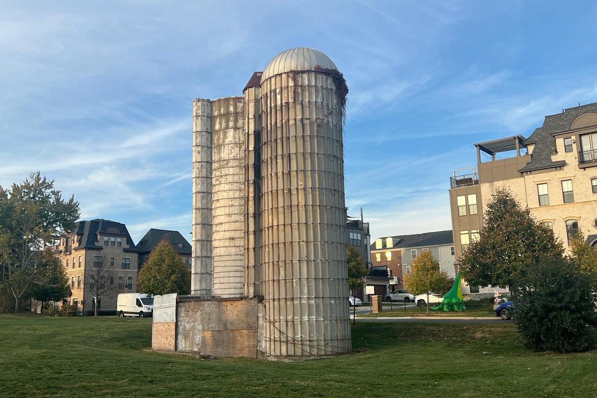 A vintage silo stands amid modern buildings and greenery in Gaithersburg, MD.