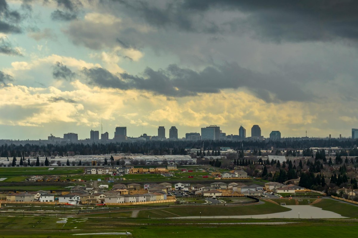 Stunning aerial view capturing the Sacramento skyline with dramatic cloudy sky, providing a picturesque cityscape.