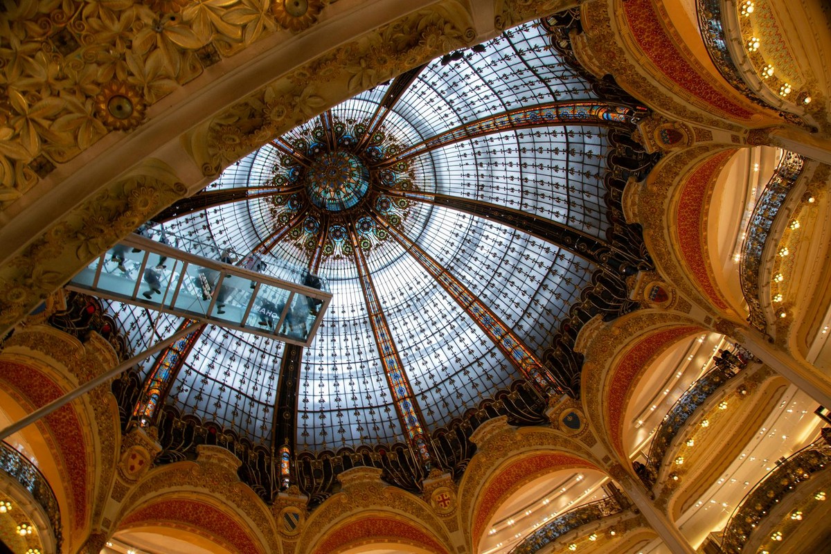 Explore the stunning dome interior of Galeries Lafayette in Paris showcasing intricate architecture.