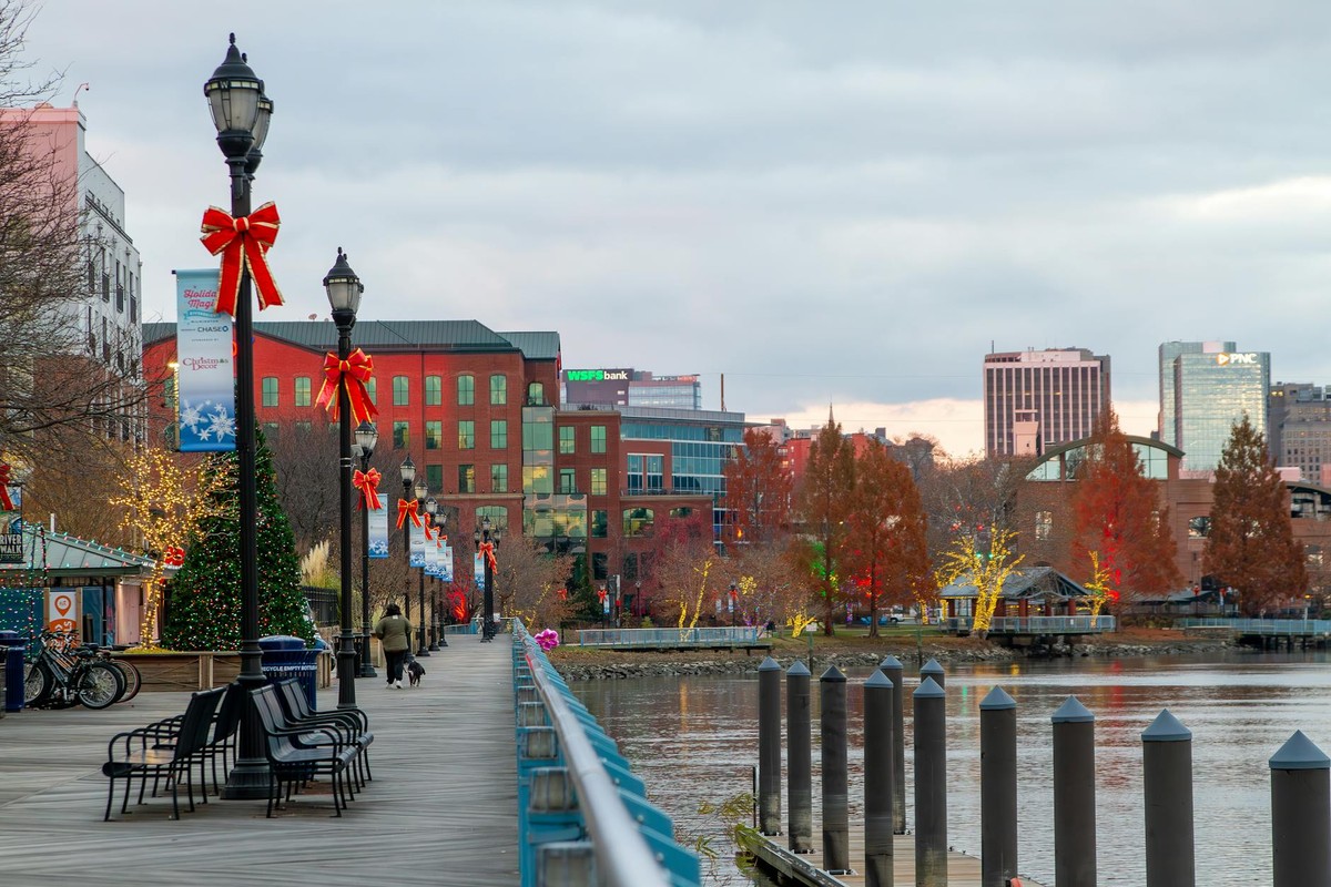 Festively decorated Wilmington riverfront with holiday lights and bows along the walkway.