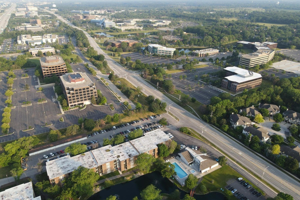 Aerial view showcasing the suburban business district in Lisle, Illinois, highlighting roads, buildings, and greenery.