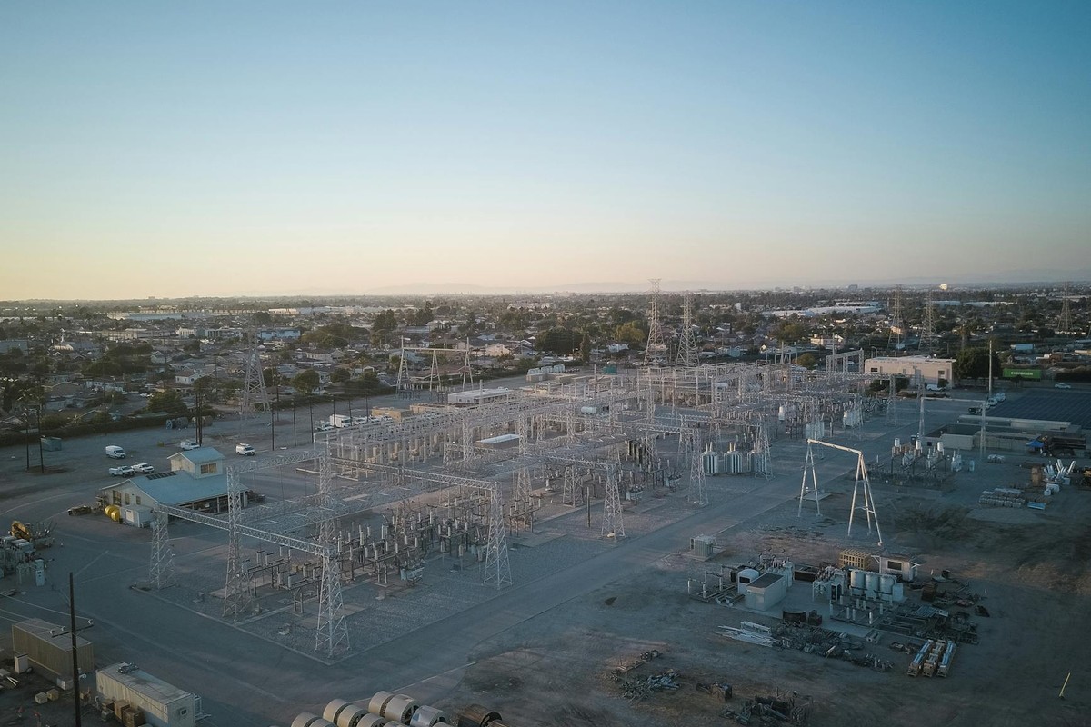 A wide view of a power station showcasing industrial infrastructure under a clear sky at sunset.
