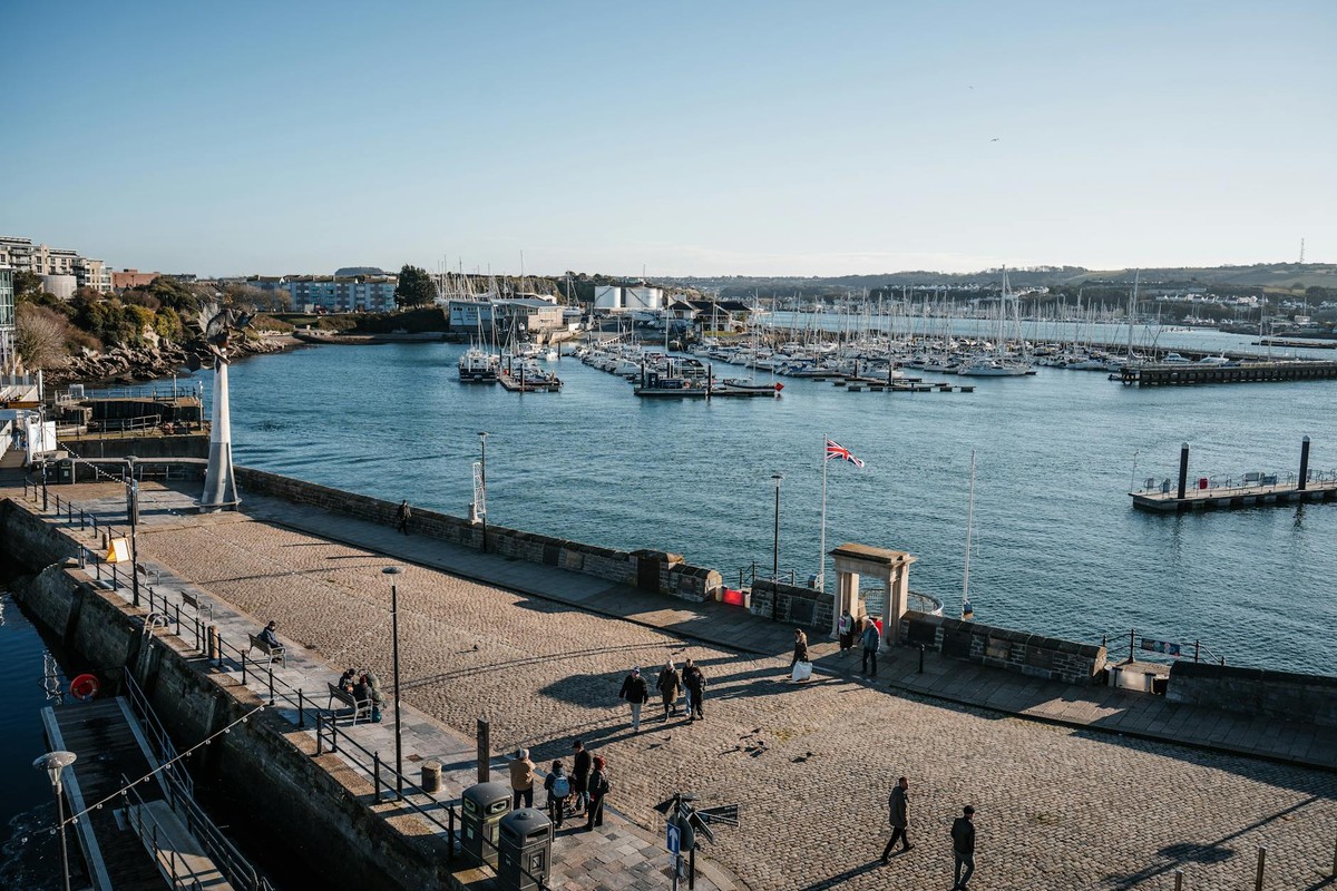 Aerial view of Plymouth Marina on a clear day with people walking on the promenade.