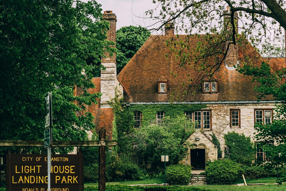 Charming stone house with ivy-covered walls in a lush garden at Lighthouse Landing Park, Evanston.