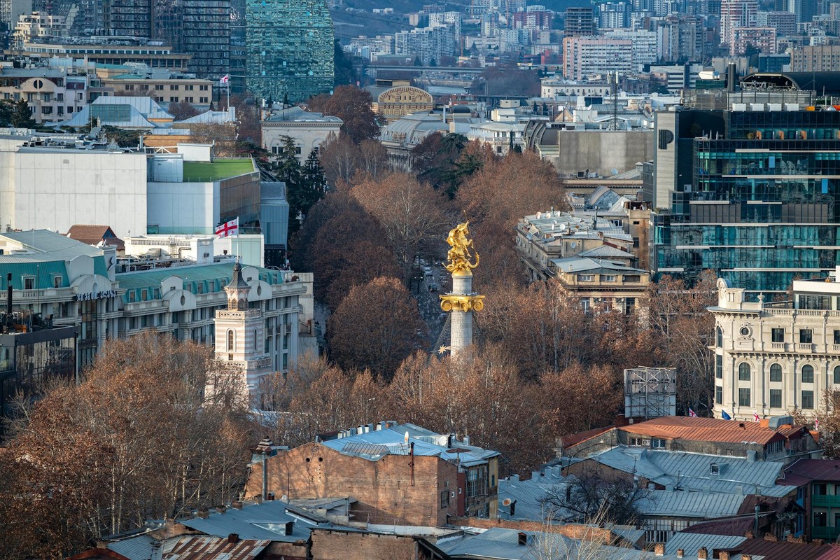 Aerial view of Tbilisi, highlighting the iconic Liberty Monument and cityscape.