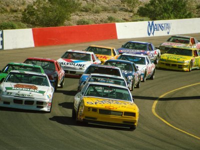 Exciting NASCAR race at Phoenix Raceway in Avondale, Arizona with colorful cars in action.