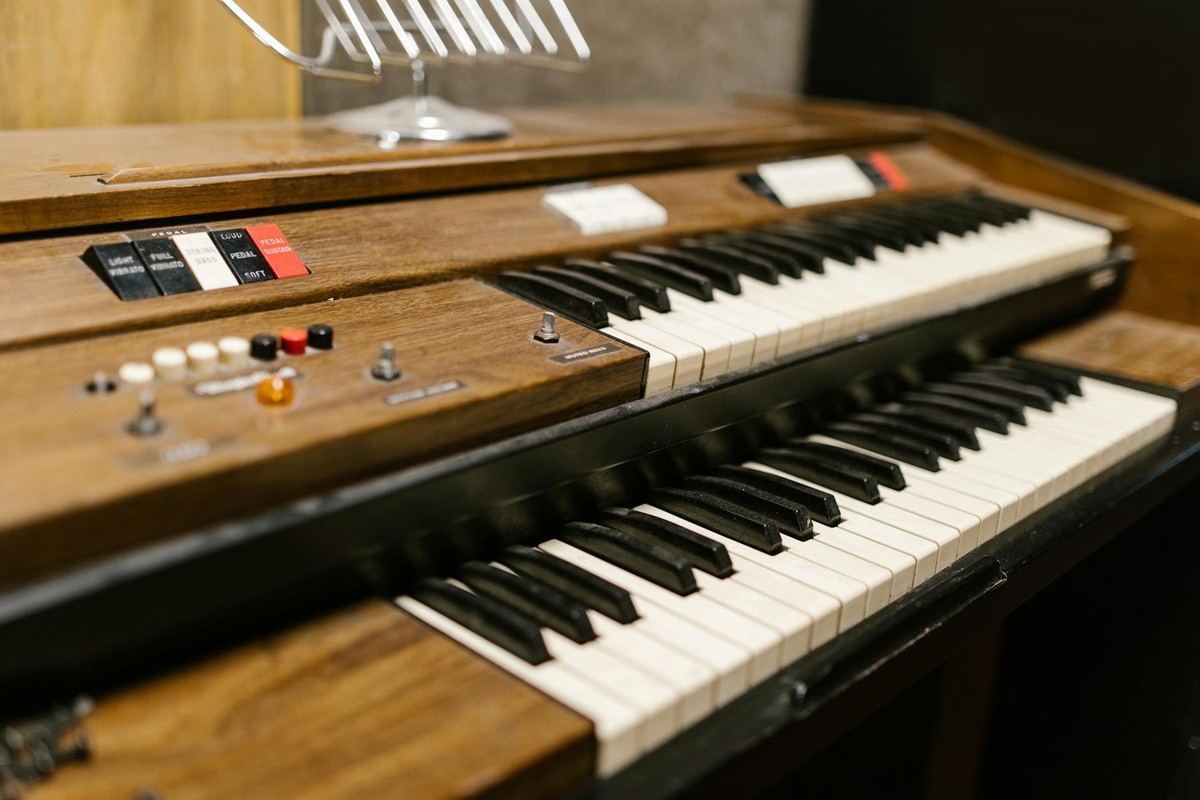 Close-up of a classic double keyboard electric organ with wooden finish and control buttons.