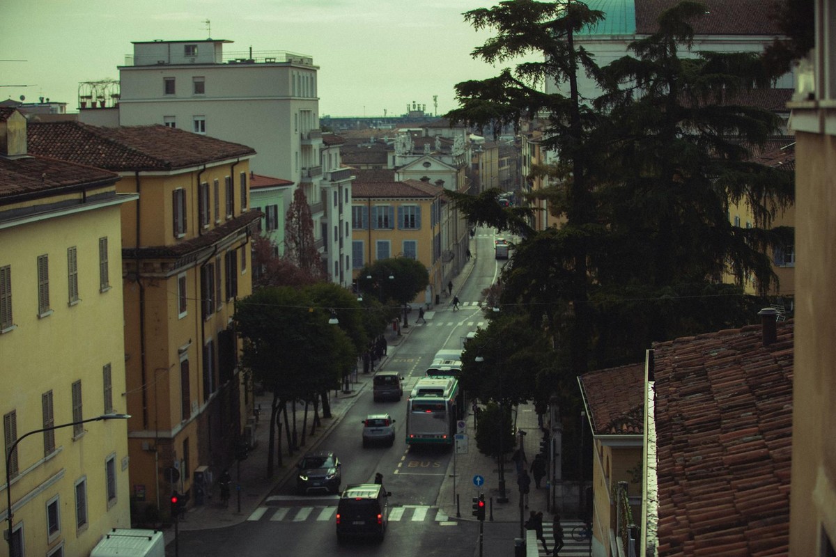Scenic view of a European city street with historic architecture and bustling traffic.