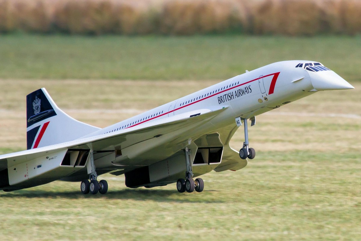 Close-up of a British Airways RC Concorde model taking off from a runway.