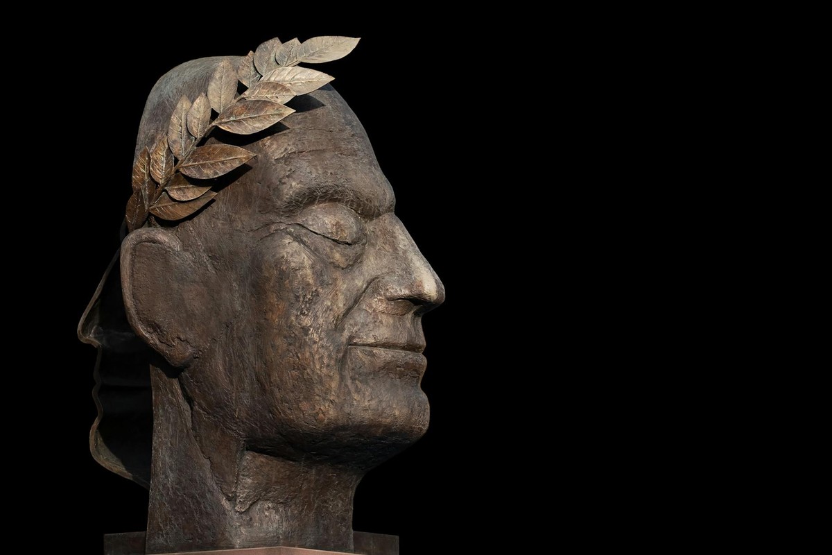 A detailed metal bust sculpture adorned with laurel leaves, symbolizing victory.