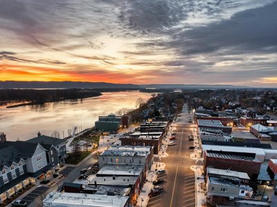 Aerial view of Wabasha, Minnesota at sunset showcasing streets, buildings, and the Mississippi River.