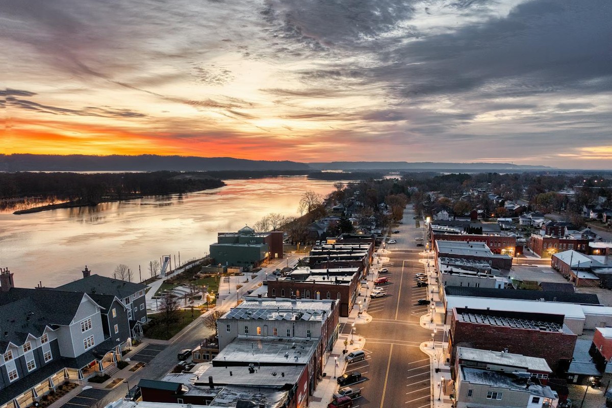 Aerial view of Wabasha, Minnesota at sunset showcasing streets, buildings, and the Mississippi River.