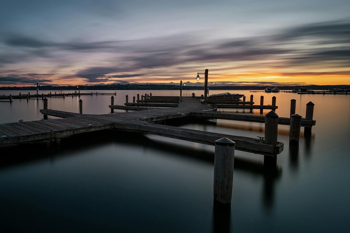 A serene sunset view at the Kirkland Marina with smooth waters and a wooden pier.