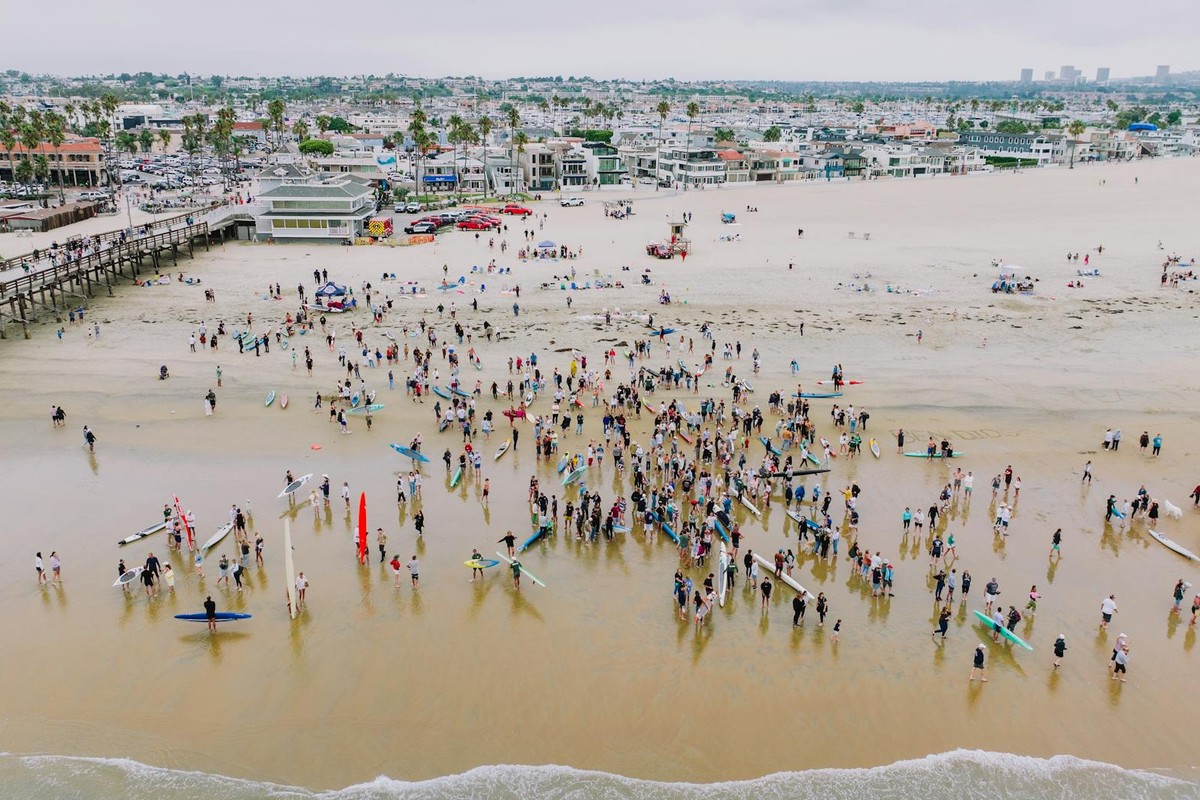 A vibrant aerial shot of surfers gathered at Newport Beach, California, showcasing community and coastal lifestyle.