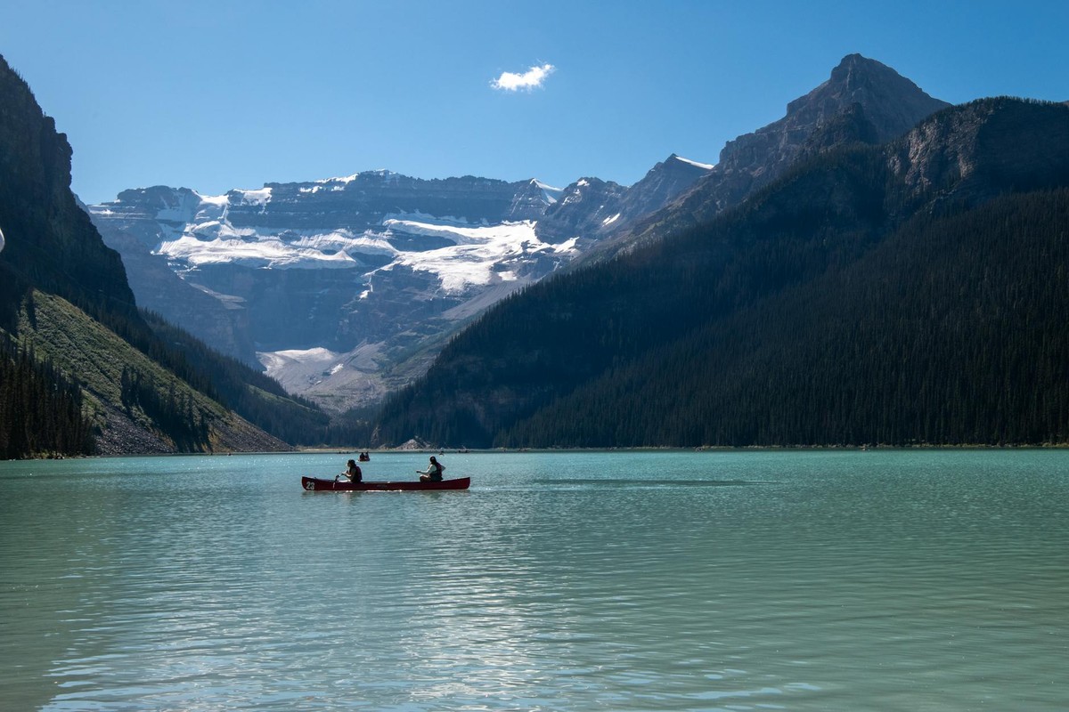 Canoeing on the pristine Lake Louise set against majestic snow-capped mountains in Alberta, Canada.