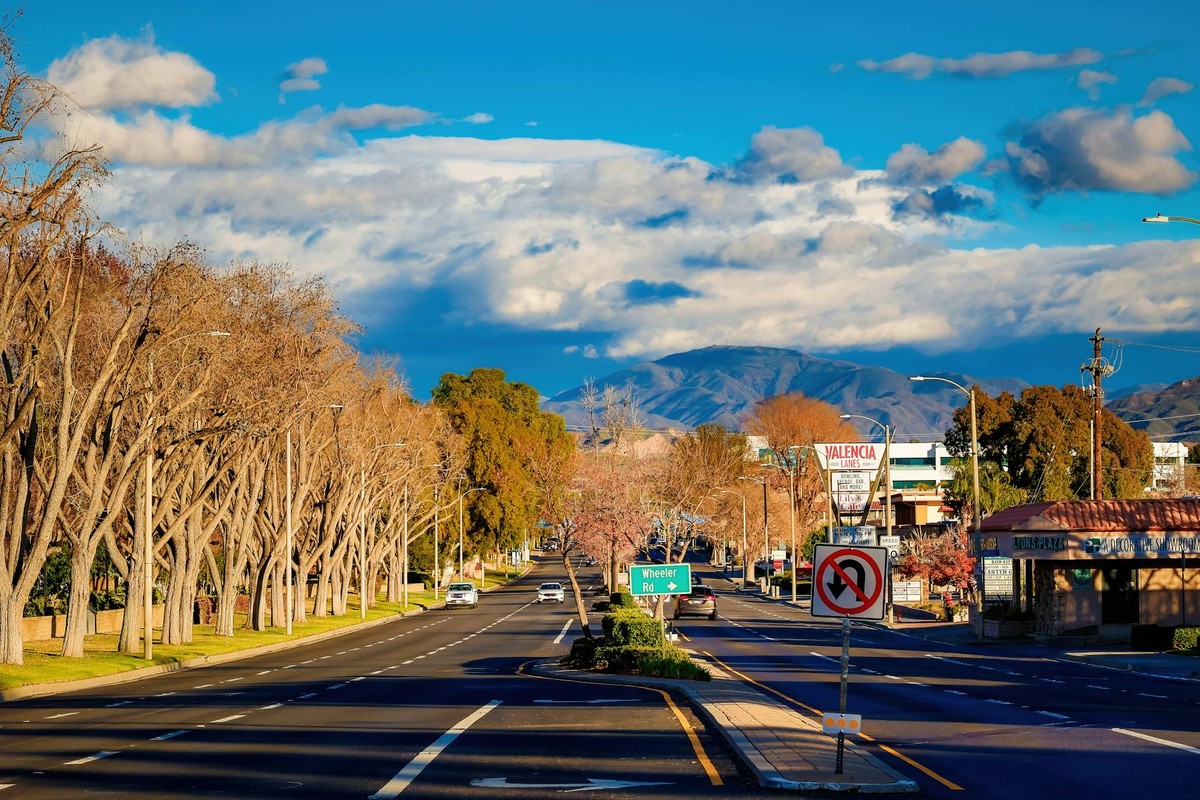 Quiet city street with distant mountains and blue sky, ideal for urban scenes.