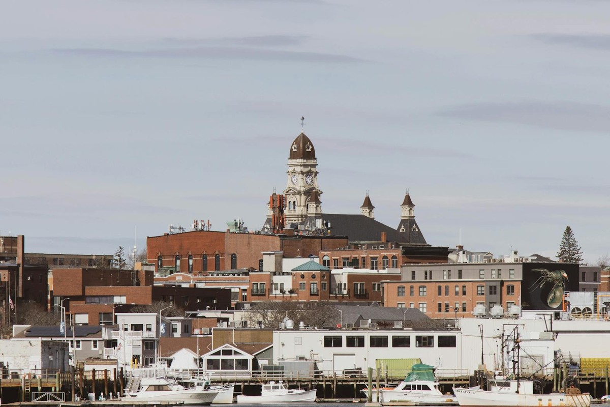 Picturesque view of a historic harbor city with boats and skyline.