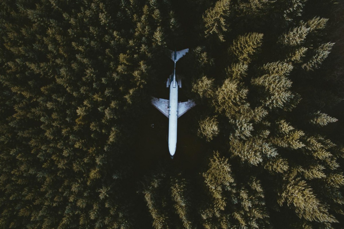 Drone shot capturing an airplane surrounded by a dense forest in Hillsboro, OR.