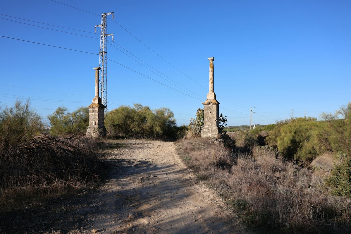 Two ancient columns stand on a historic path in El Puerto de Santa María, Spain.