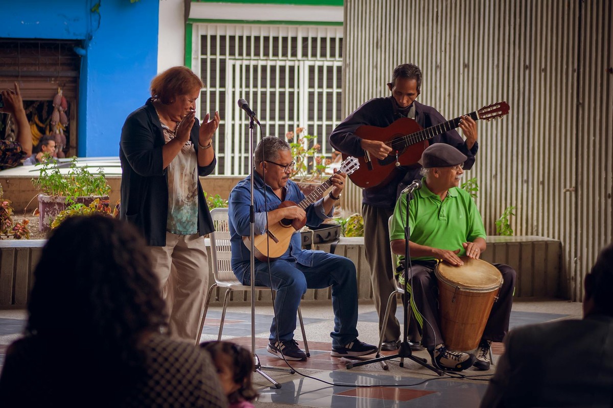A diverse group of senior musicians performing outdoors in Venezuela, showcasing traditional musical talent.