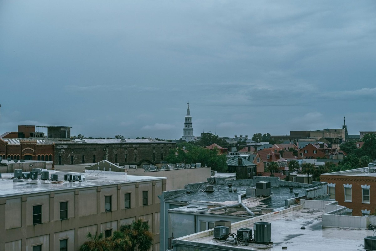 Aerial cityscape of Charleston, SC showcasing historic architecture under a cloudy sky.
