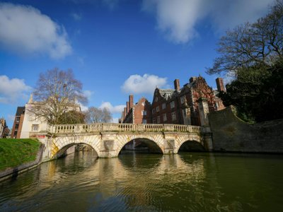Capture of a historic stone bridge in Cambridge with clear blue skies and classic architecture.