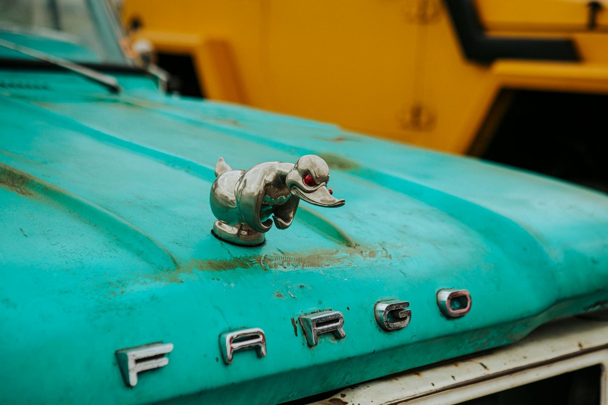 Close-up of a vintage Fargo truck hood showcasing a chrome duck hood ornament.