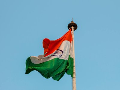 Indian national flag waving proudly against a clear blue sky in Jaipur, symbolizing patriotism and unity.