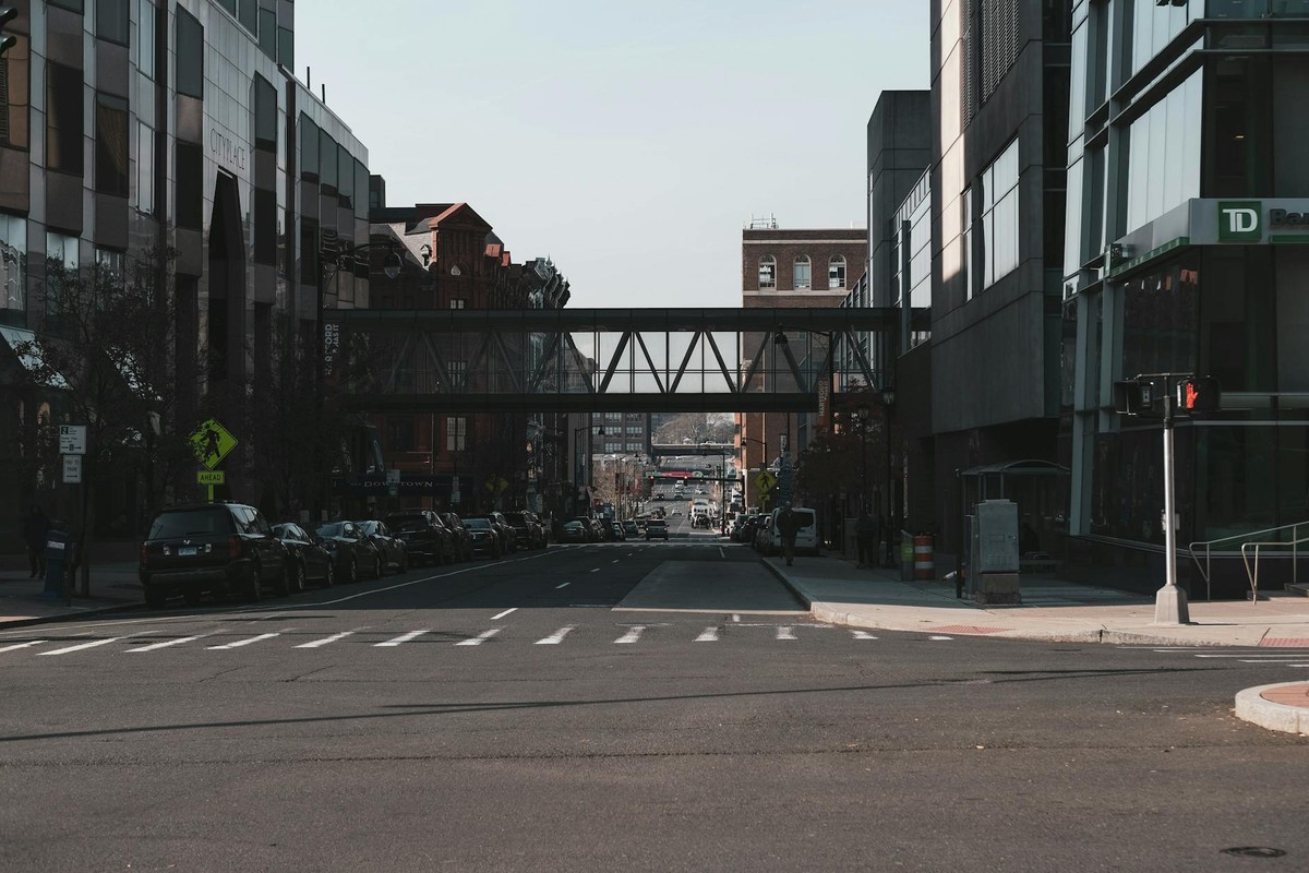 Street view of downtown Hartford, CT featuring modern and historic architecture with an overhead walkway.
