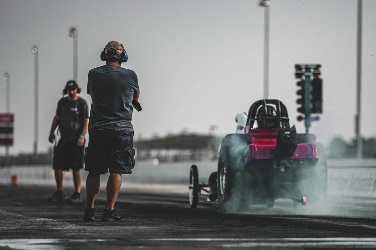 High-speed drag racing action captured on a sunny day at Topeka Raceway.