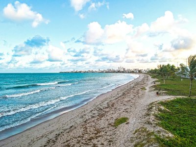 A serene view of Intermares beach in Brazil with waves and clear blue sky.