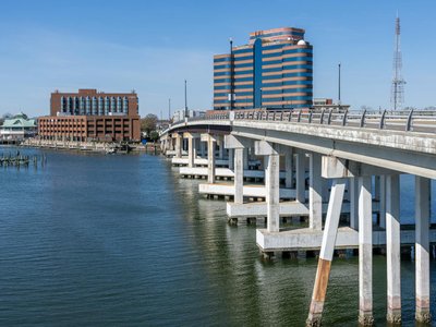 View of Hampton Harbor with prominent bridge and waterfront buildings on a clear day.