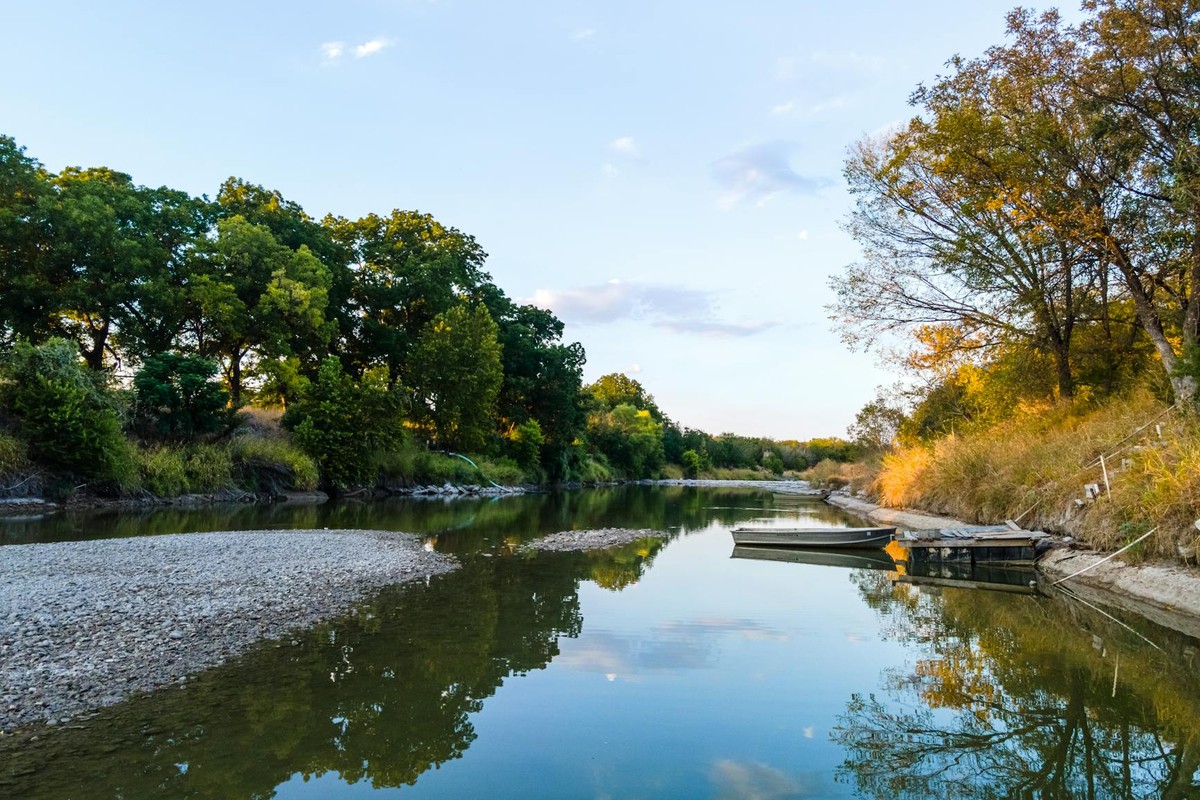 Serene scene of a tranquil lake and boat at sunset in Killeen, Texas, reflecting the beauty of nature.