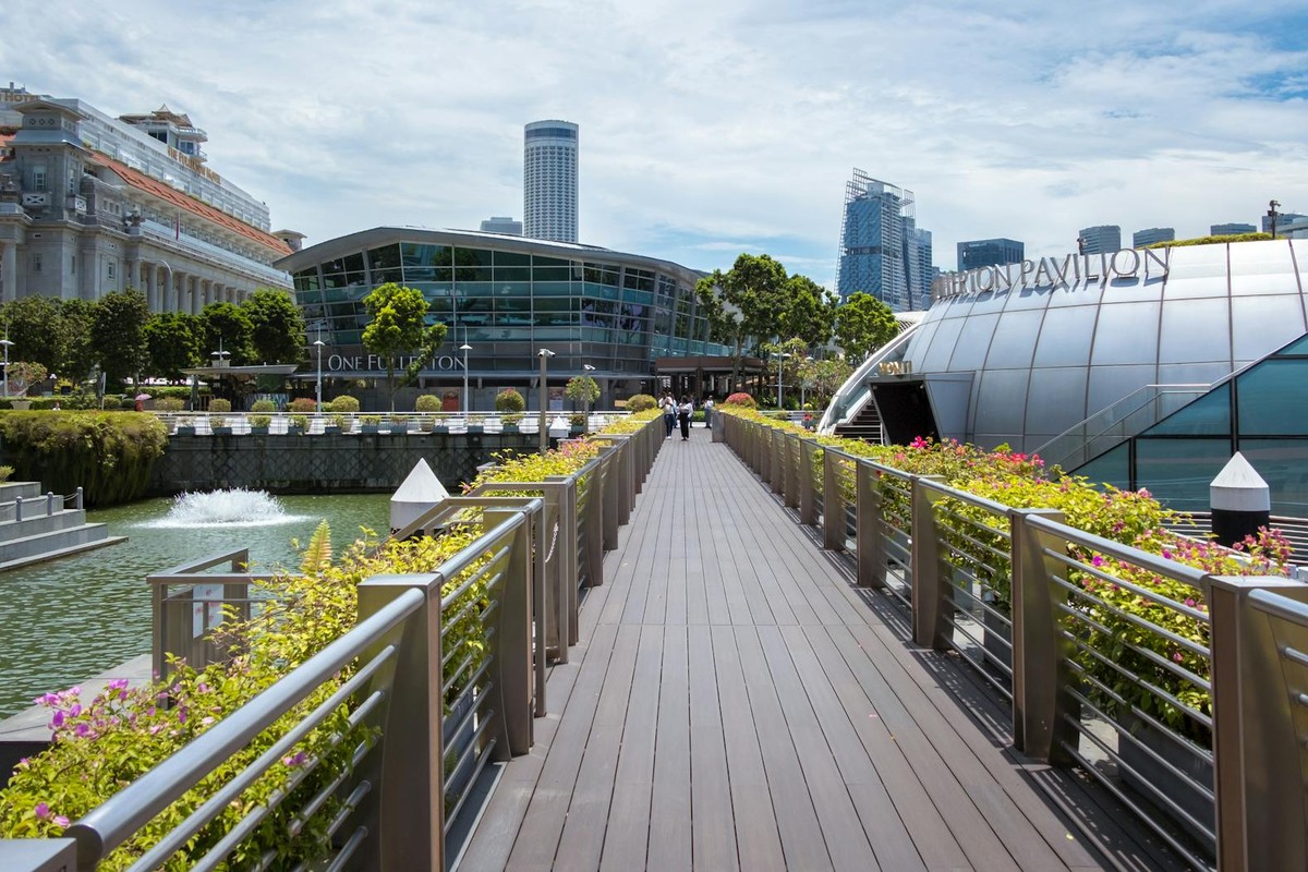 A sunny day view of the scenic walkway near One Fullerton and the Fullerton Pavilion in Singapore.