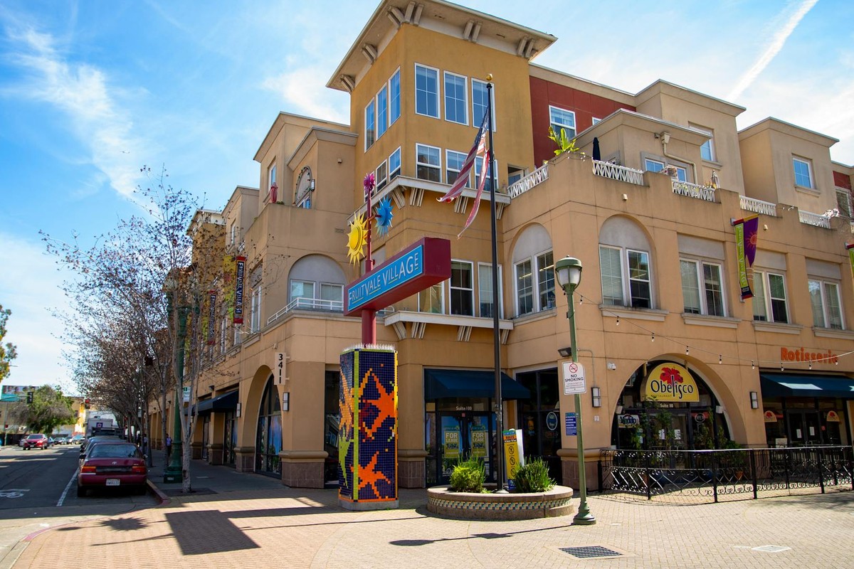 Colorful building exterior of Sunnyvale Village under a clear blue sky.