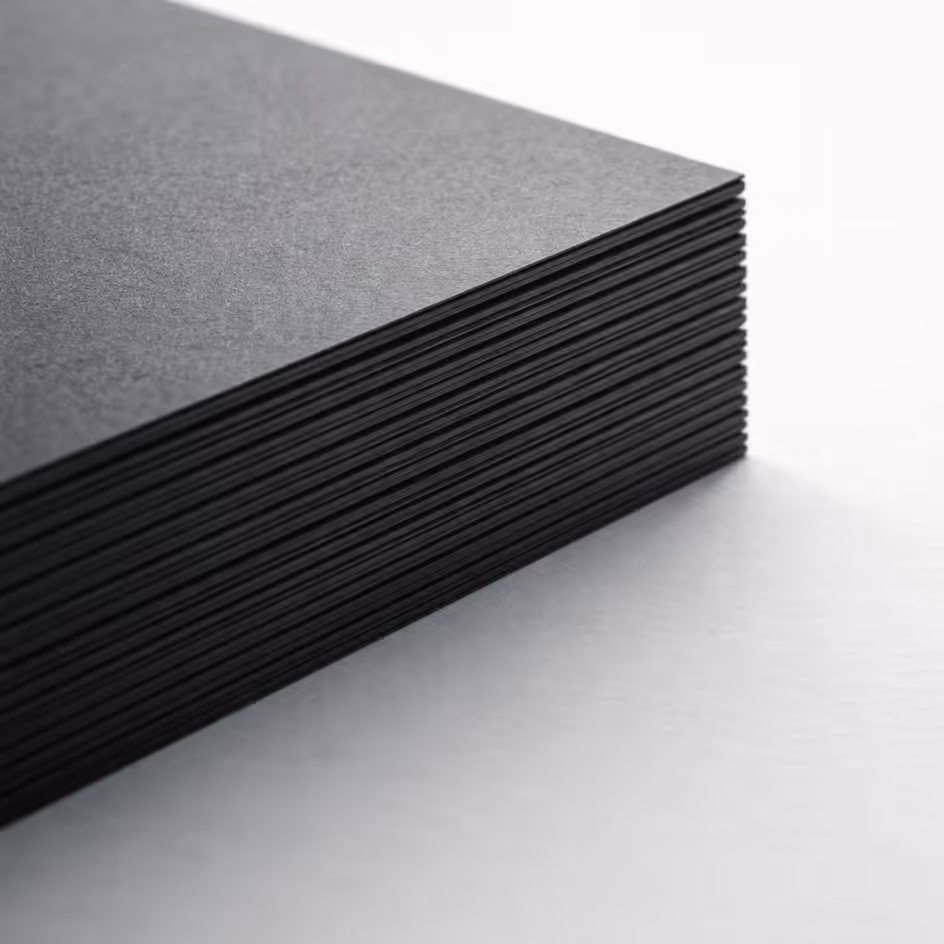 A close-up of stacked, thick dark paper layers on a light surface, representing meticulous preparation, strategic depth, and the tangible quality of professional collaboration.
