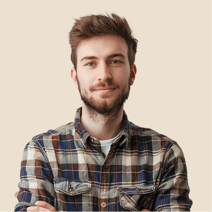 Young man with short brown hair and beard wearing a plaid shirt against a plain beige background.
