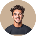 Smiling young man with curly hair and trimmed beard wearing a dark shirt on a beige background.