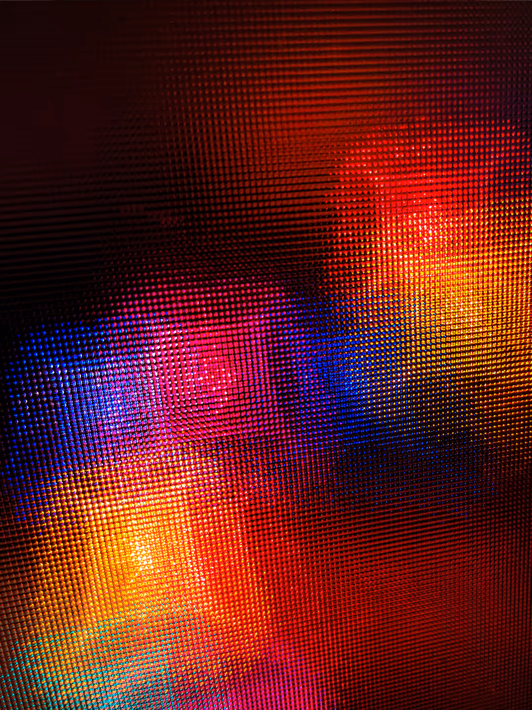 Colorful blurred lights in red, blue, yellow, and purple behind a textured grid surface.