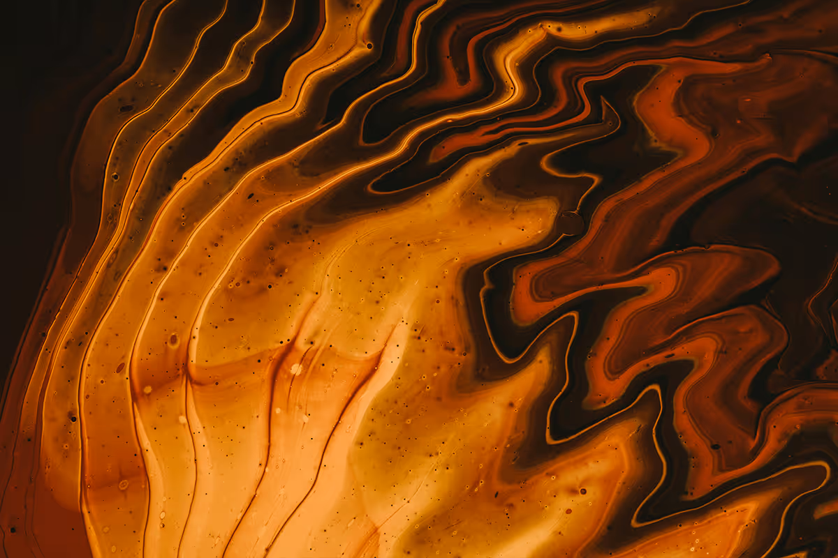 Swirling abstract pattern in shades of orange, brown, and black resembling flowing liquid art.