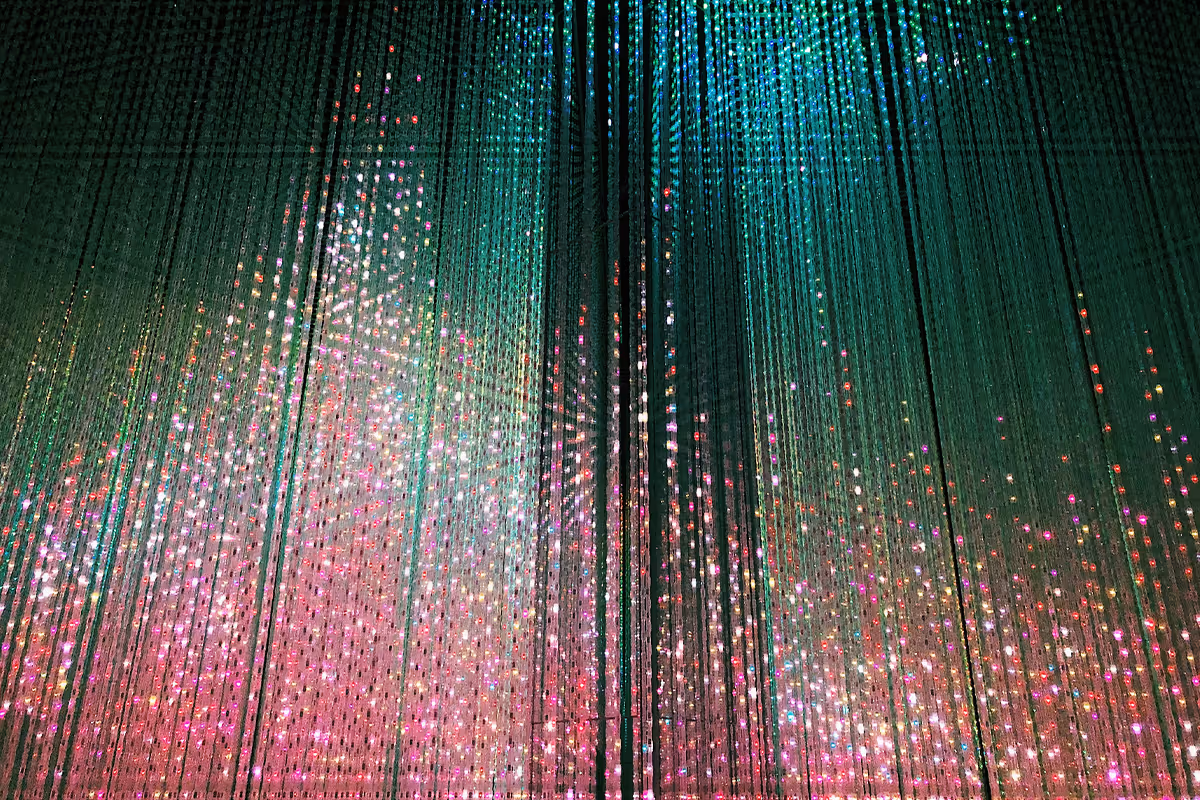 Strings of hanging lights in green, pink, and white create a shimmering curtain effect.