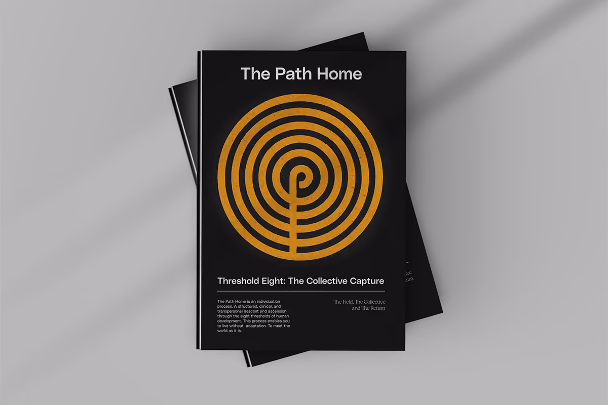 Book titled The Path Home with an orange labyrinth design on black cover lying on gray surface.