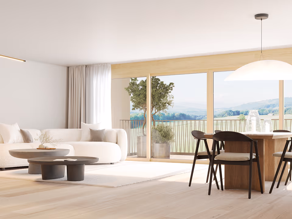 Bright modern living room with white sofa, round coffee tables, wooden dining table with chairs, and large glass doors opening to a balcony with plants and scenic view.