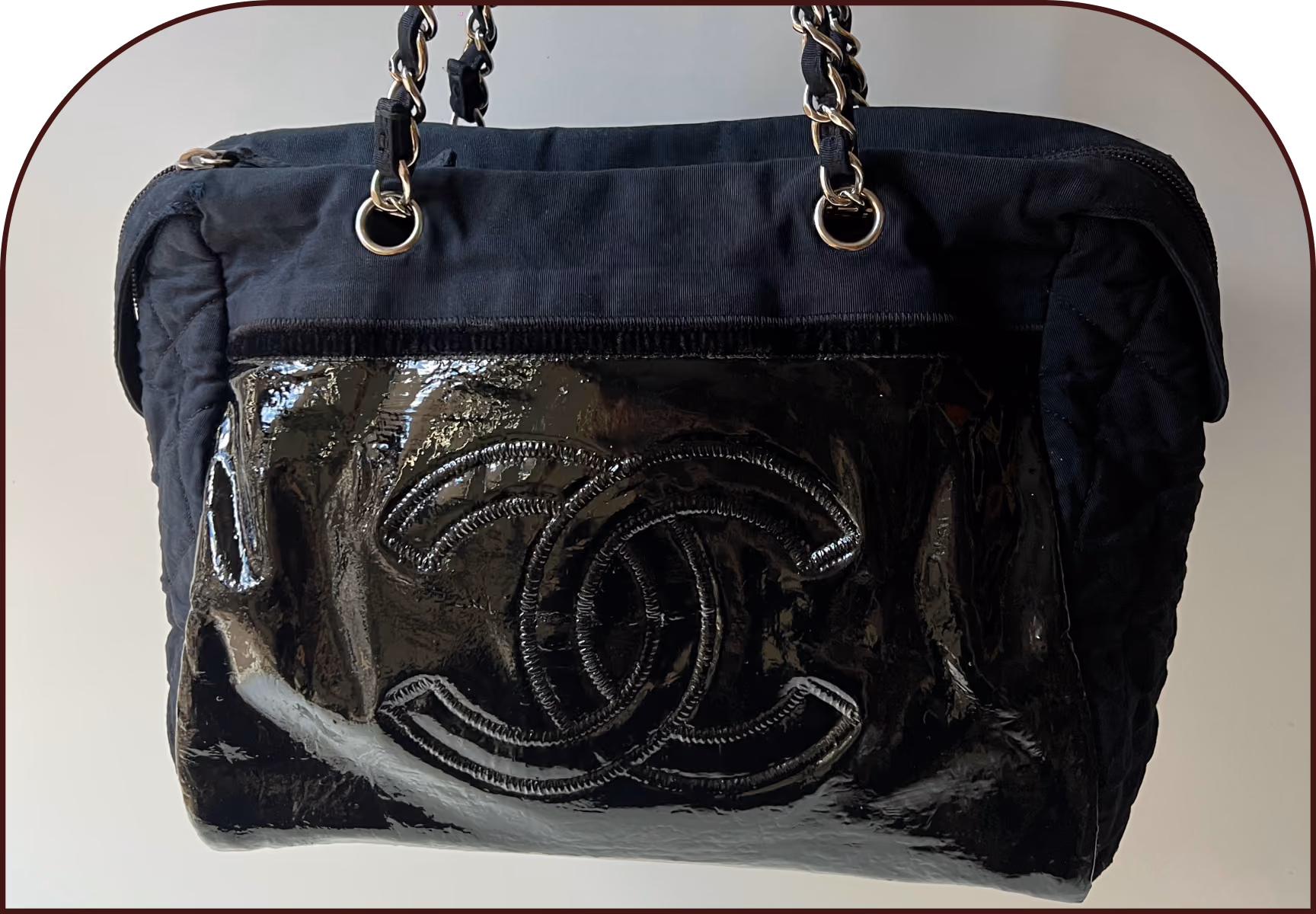 Chanel patent leather bag showing cracked, peeling finish on the CC logo panel after repair by The Reco Lab
