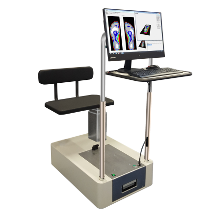 Foot pressure measurement system with a black padded seat, a monitor displaying foot pressure maps, and a keyboard on a stand.