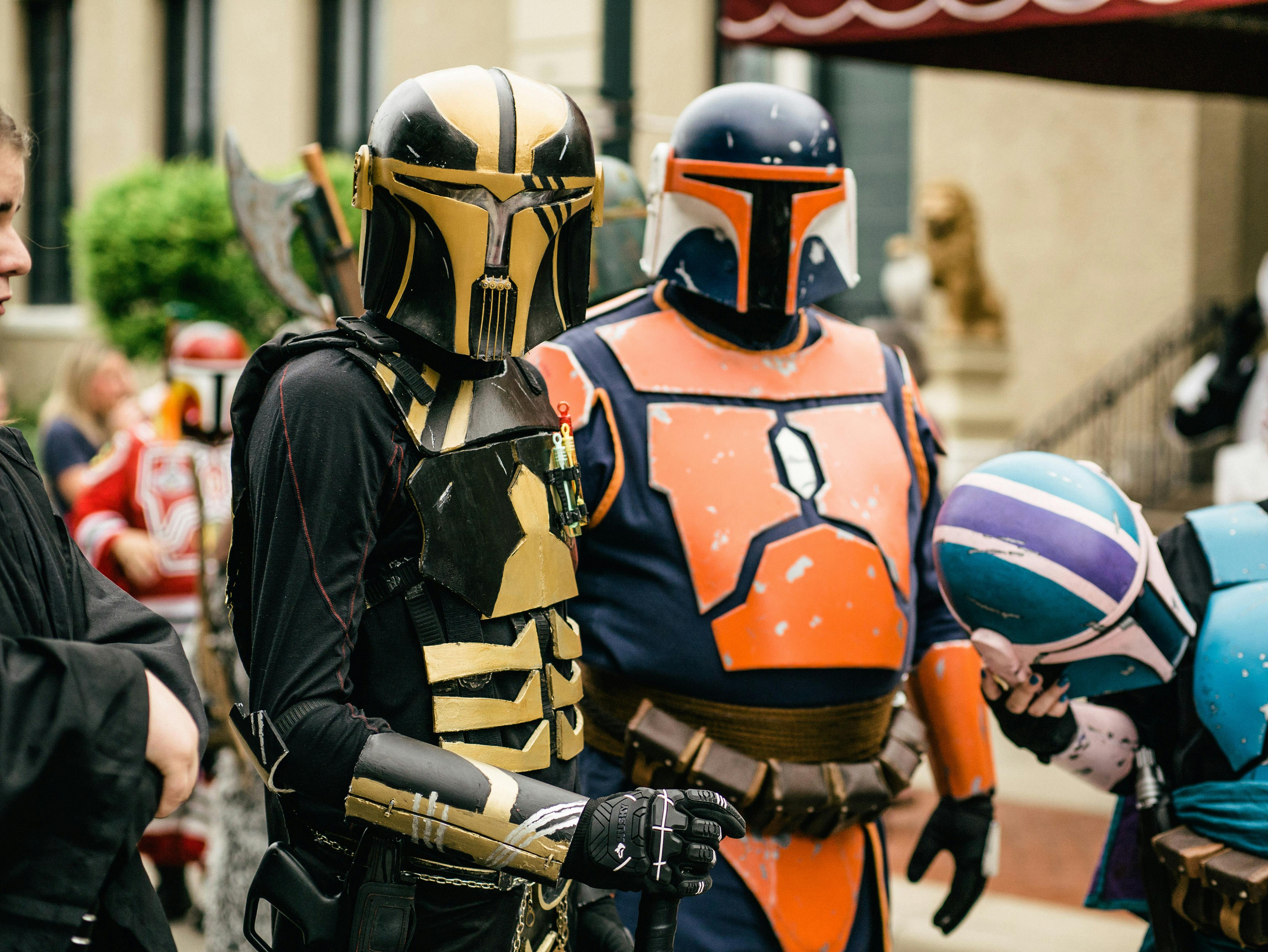Group of people dressed in detailed Mandalorian-style armor costumes outdoors.