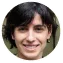 Portrait of a smiling young man with dark hair wearing a dark shirt.